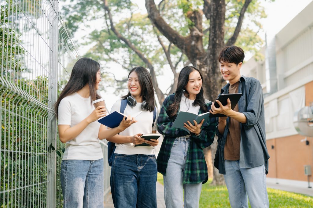 Young college students and student group work at the campus park
